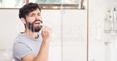 Keep it fresh, look your best. Shot of a handsome young man singing while brushing his teeth at home.