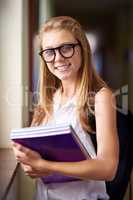 She's a diligent student. Shot of a young girl in her school hallway.