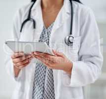 Convenient access to all things health. Cropped shot of an unrecognizable doctor using a digital tablet while working in a clinic.