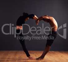 Unity is strength. A female and male contemporary dancer performing a dramatic pose in front of a dark background.