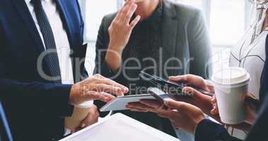 Technology helps our business move faster. Cropped shot of an unrecognizable group of businesspeople standing and using technology while in the office.