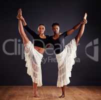 Sisters in symmetry. Two young female contemporary dancers using a soft white white skirt for dramatic effect.