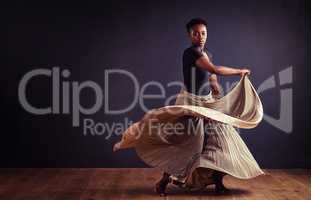 Feel the motion. Female contemporary dancer in a dramatic pose against dark background.