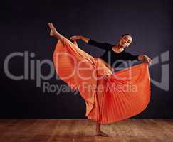 Free form dancing. Female contemporary dancer in a dramatic pose against dark background.