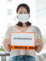 Im a SURVIVOR. Shot of a woman holding up a sign with CORONAVIRUS on it.