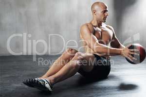 Working his core muscles. Shot of a man working out with a medicine ball at the gym.