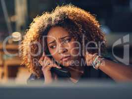 Thats not what I wanted to hear. Shot of a young businesswoman making a stressful phone call during a late night at work.
