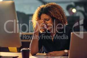 In the grip of occupational stress. Shot of a young businesswoman experiencing stress during a late night at work.