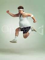 I feel in shape already. Overweight man leaping in the air with his sense of achievement.