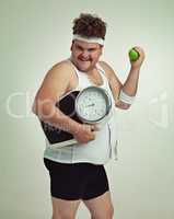 Lets do this. Cropped shot of an overweight man holding a apple,scale and measuring tape.