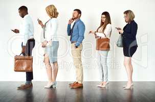 Theyre ready to get going. Studio shot of a group o focused people standing in a row behind each other against a white background.