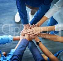 Lets awaken the team spirit. High angle shot of a group unrecognizable businesspeople joining their hands together in unity.