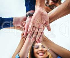 Theyre ready to go. Low angle shot of a group of unrecognizable businesspeople joining their hands together in unity.