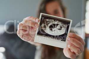 Look at my little peanut. Shot of a woman holding a sonogram of her unborn baby.