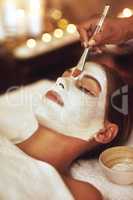 Let your beauty rise to the surface. Shot of a young woman enjoying a facial treatment at the spa.