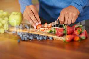 Cutting calories out of his diet. Cropped shot of a man preparing a healthy and fruity snack.