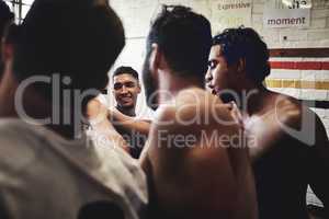 Team spirit is everything. Cropped shot of a group of handsome young rugby players standing together in a huddle in a locker room.