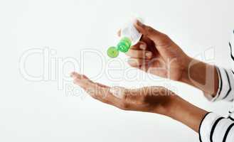 Like a life saver in a bottle. Cropped shot of a woman using hand sanitiser against a white studio background.