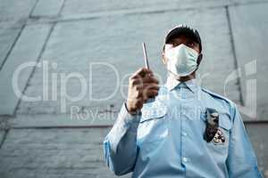 Proactive guarding for your propertys protection. Shot of a masked young security guard using a two way radio while on patrol outdoors.