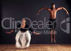 Flight. A female and male contemporary dancer performing a dramatic pose in front of a dark background.