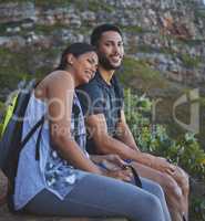 Sunsets are better with you by my side. Shot of a young couple enjoying the sunset view while out on a hike on a mountain range.