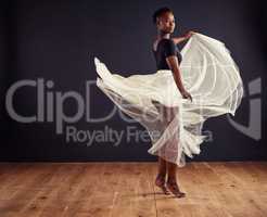 Freedom of movement. Young female contemporary dancer using a soft white white skirt for dramatic effect.