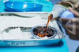 Nothing goes unsterilized. Cropped shot of a doctor pouring antiseptic into a bowl before a medical procedure.