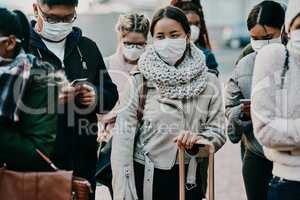 Navigating a new way of life. Shot of a group of young people wearing masks while travelling in a foreign city.