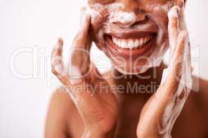 I wash my face twice a day. Studio shot of an unrecognizable woman washing her face against a white background.