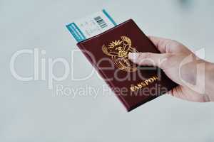 A ticket to freedom. Cropped shot of a woman holding her passport and boarding pass in an airport.