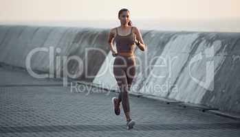 Fresh air runs are the most energising. Shot of a sporty young woman running outdoors.