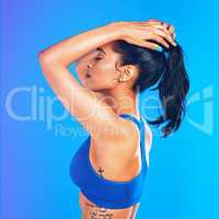 Tired but not defeated. Studio shot of an attractive young sportswoman posing against a blue background.