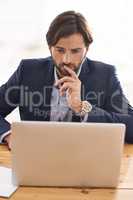 Good results require focus and patience. A handsome businessman sitting at his desk and working on his laptop.