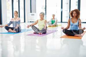 In perfect harmony. Shot of a group of women meditating indoors.
