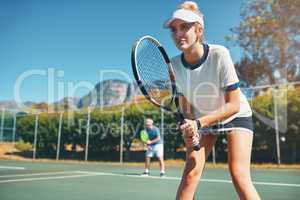 Champions play with heart and dedication. Cropped shot of an attractive young female tennis player playing together with a male teammate outdoors on a court.