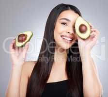 Going organic was a move in the ripe direction for me. Studio portrait of an attractive young woman posing with an avocado against a grey background.