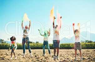 Time flies when you're having fun. Shot of a group of teenagers having fun with colourful powder at summer camp.