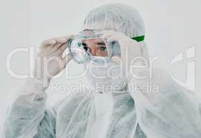 Time to get things under control. Shot of a young man putting on his protective gear before the decontamination process.