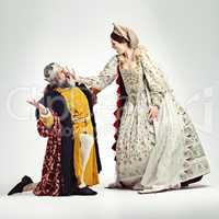 How very dare you. Studio shot of a queen slapping a kneeling king in the face.