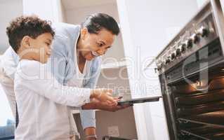 Are you excited to see what you made. Shot of a mature woman helping her grandchild safely open the oven at home.