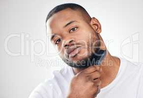 Facial hair care is a delicate art. Studio portrait of a handsome young man brushing his facial hair against a white background.