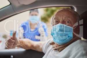 Stay safe and get vaccinated. Shot of a senior man and a young healthcare worker showing a thumbs up at a drive through vaccination site.