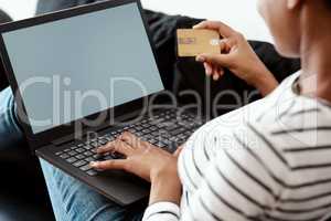 Timeout in the cyberspace shopping mall. Cropped shot of a woman using a laptop and credit card on the sofa at home.