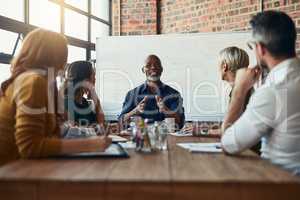 Dictating the direction of the meeting. Cropped shot of a mature businessman leading a meeting in the boardroom.