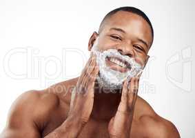 Forming a foamy cushion on the face before shaving. Studio portrait of a handsome young man applying shaving cream to his face against a white background.