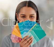 Every colour for your every need. Shot of a young woman holding different colour swatches while renovating her house.