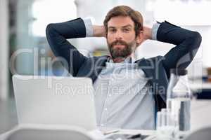 He takes his job very seriously. Shot of a young businessman sitting at his workstation in an office.