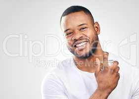 Grooming plays a major role in maintaining a high self-esteem. Studio portrait of a handsome young man spraying perfume on himself against a white background.