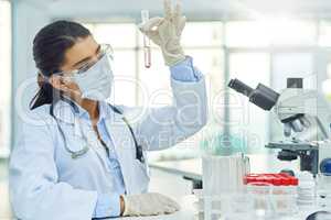 Working hard to make her contribution towards the sciences. Shot of a young scientist working in a lab.