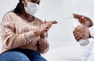Clean hands keep us from spreading viruses. Closeup shot of an unrecognisable doctor giving hand sanitiser to a patient.